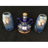 A Royal Doulton art nouveau style twin-handled candle holder decorated with flowers to a blue