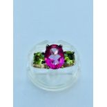 A ladys 9ct yellow gold pink Tourmaline and peridot ring. The oval shaped Tourmaline measures 7mm