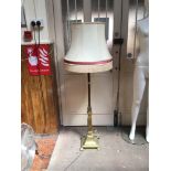 A brass lamp standard, the support of square section, with floral decoration and raised on down-