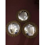 Three circular convex mirrors with gold lacquered pierced foliate composition frames