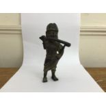 A Benin bronze figure of a standing man playing a side blown horn or flute, with ornate hat and