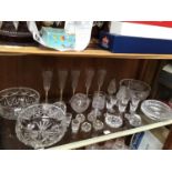 A shelf of assorted cut glass including Waterford Crystal ashtray (af), large bowls, glasses, candle