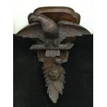 A Victorian carved oak wall bracket, supported by an eagle on perch above fruit and foliage, 43 cm