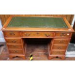 A reproduction yew wood pedestal desk with inset gilt-tooled scribe, 120cm wide