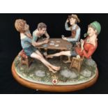 A large Capodimonte figure group 'The Cheats' four young boys playing cards, maker's mark and