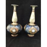 A pair of early 20th century Royal Doulton stoneware vases, of onion form, painted in tones of blue,