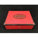 A large humidor / cigar box with humidity control, compartmented interior, red lacquer finish with