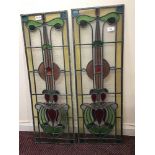 A pair of rectangular leaded, stained glass panels, each decorated with floral designs in blue,