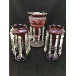 A pair of Victorian ruby glass lustres with artichoke leaf shaped rims, each with eight cut glass
