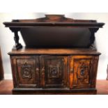A late 19th century stained oak Gothic Reform two-tier buffet, with a pair of base cupboard doors,