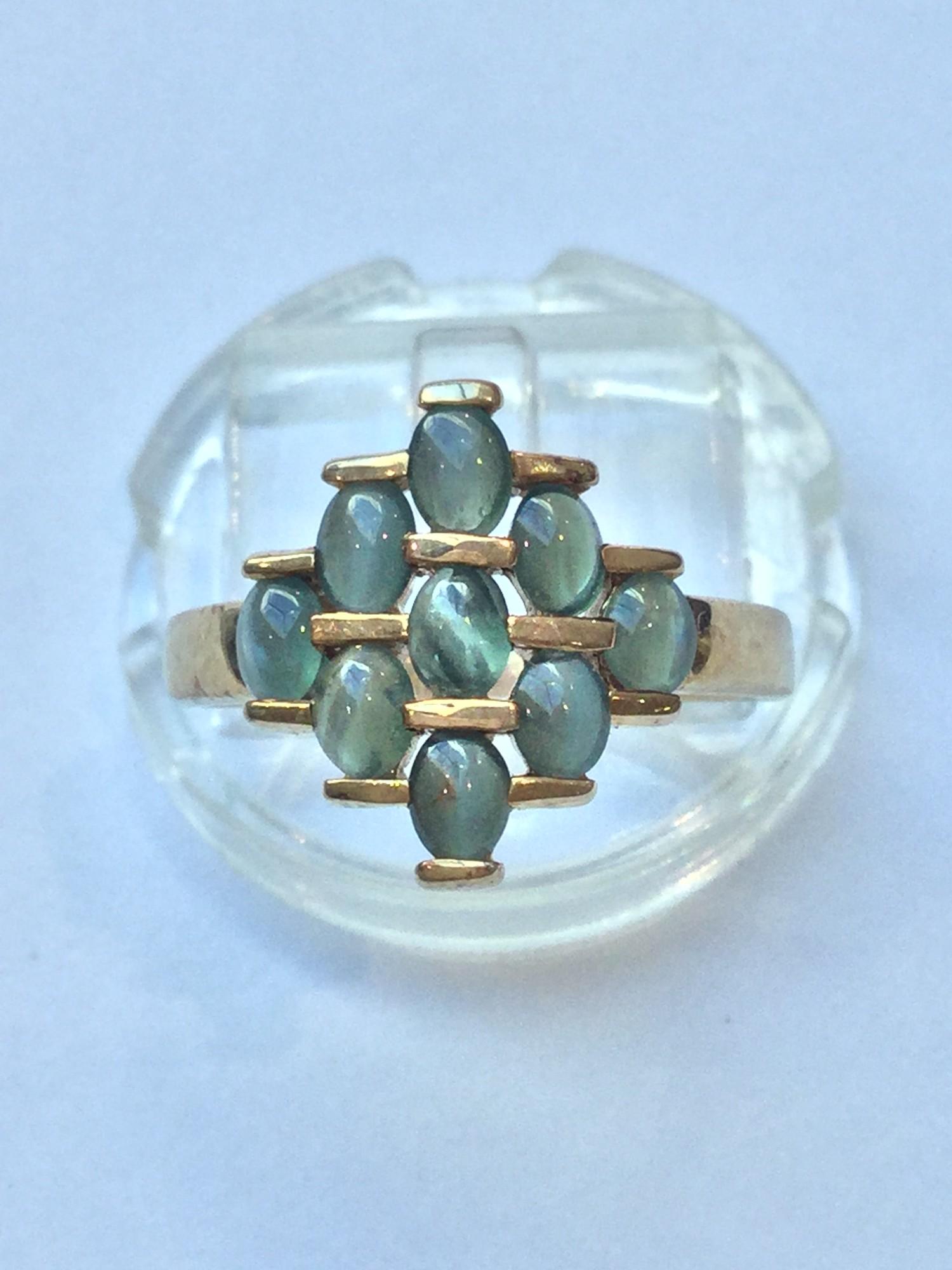 A 9ct gold dress ring, set with 9 x green cabochon stones. Ring weighs 3.2 grams, finger size N.