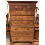 A George III walnut chest on chest, the top section with shaped cornice and dentil moulding, above a