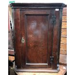 A George III mahogany bow-front hanging corner cupboard, with herringbone cross-banding, enclosed