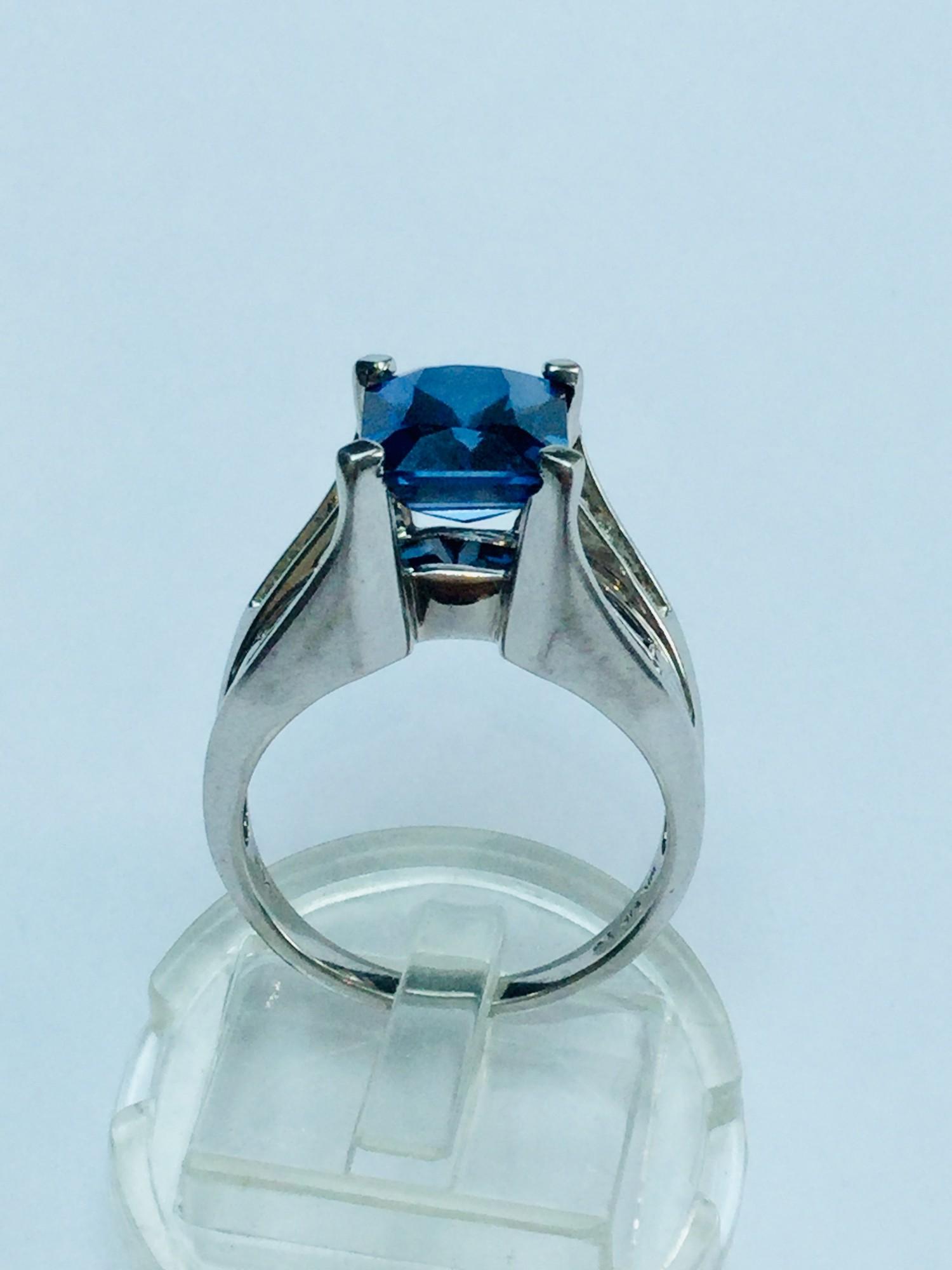 A ladys 10ct gold ring set with an emerald cut sapphire to the centre. Under the bezel is set 7 x - Image 3 of 3