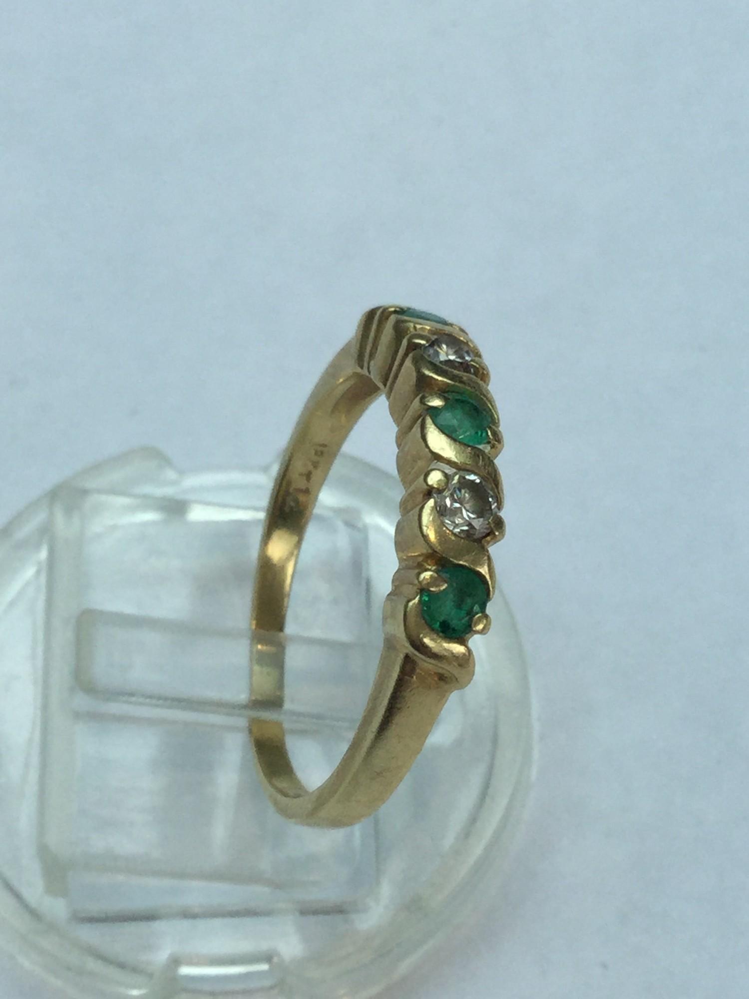 A lady's 18ct yellow gold Emerald & Diamond ring. Set with three round cut emeralds and two round - Image 2 of 3