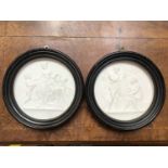 A pair of Continental bisque porcelain circular plaques, relief carved with scenes from the Four