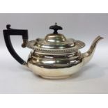 A George V Silver Teapot of compressed oblong form, with ebony finial and handle, and gadrooned rim,