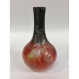 A Bernard Moore Art Pottery vase of shaft and globe form, decorated with mottled blue and red flambe