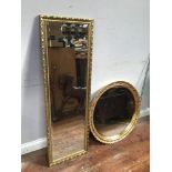 A gilt edged rectangular bevelled mirror, 124x40cm, together with a circular mirror with gilt border