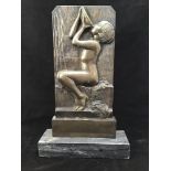 An art deco relief cast bronze plaque of a seated naked lady drinking from a bowl, raised on a