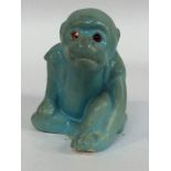 A Bernard Moore Art Pottery model of a seated monkey wearing a waistcoat, finished in turquoise