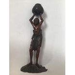 A bronze figure of a semi clad Oriental man holding aloft a basket, standing on a seashell, possibly