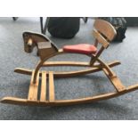 A 1970s vintage child's beechwood rocking horse with red vinyl set