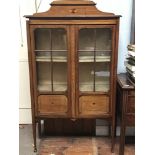 An Edwardian inlaid display cabinet with shaped and raised back, pair of glazed and panelled doors
