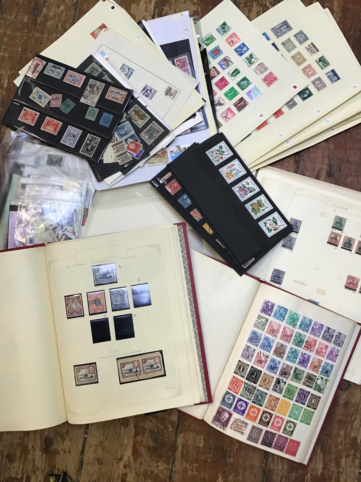 A collection of assorted used and unused world stamps across multiple albums, largely loose