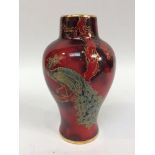 A Bernard Moore Art Pottery vase of inverted baluster for decorated with a peacock amidst branches