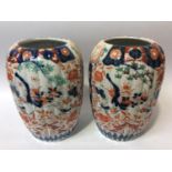 A pair of Japanese Imari porcelain vases of reeded ovoid form, painted with typical decoration, 24cm