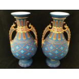 A pair of Mettlach twin-handled vases, of baluster form with beaded necks, ornate scrolled brown