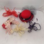 collection of fascinators and accessories including a red hat with blue netting, pink gloves with