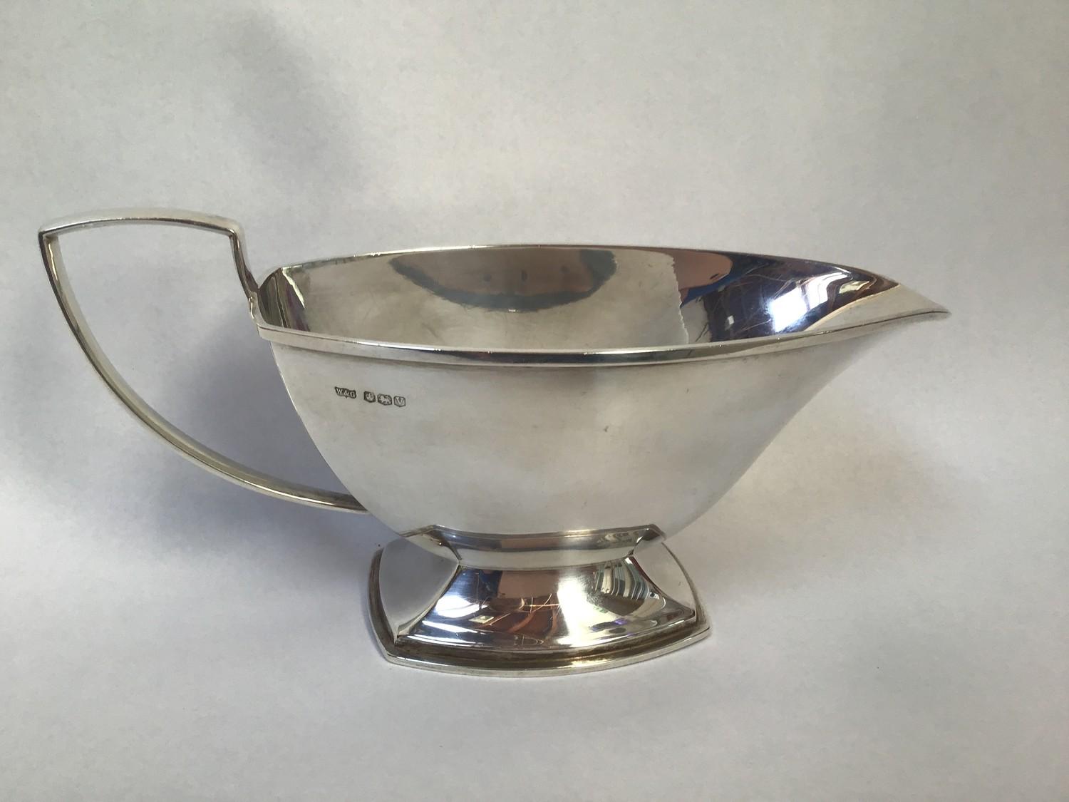 A silver sauce boat with angular mid section, shaped handle, hallmarked Sheffield, 1938, maker's