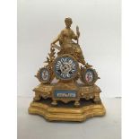 A gilt ormolu figural mantel clock surmounted with a lady holding a torch reading a book,