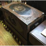 An oriental-carved teak domed top coffer on stand, with camphor wood lining, carved with fully-