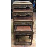 A nest of four oriental rosewood occasional tables, carved with geometric scrolling cloud bands