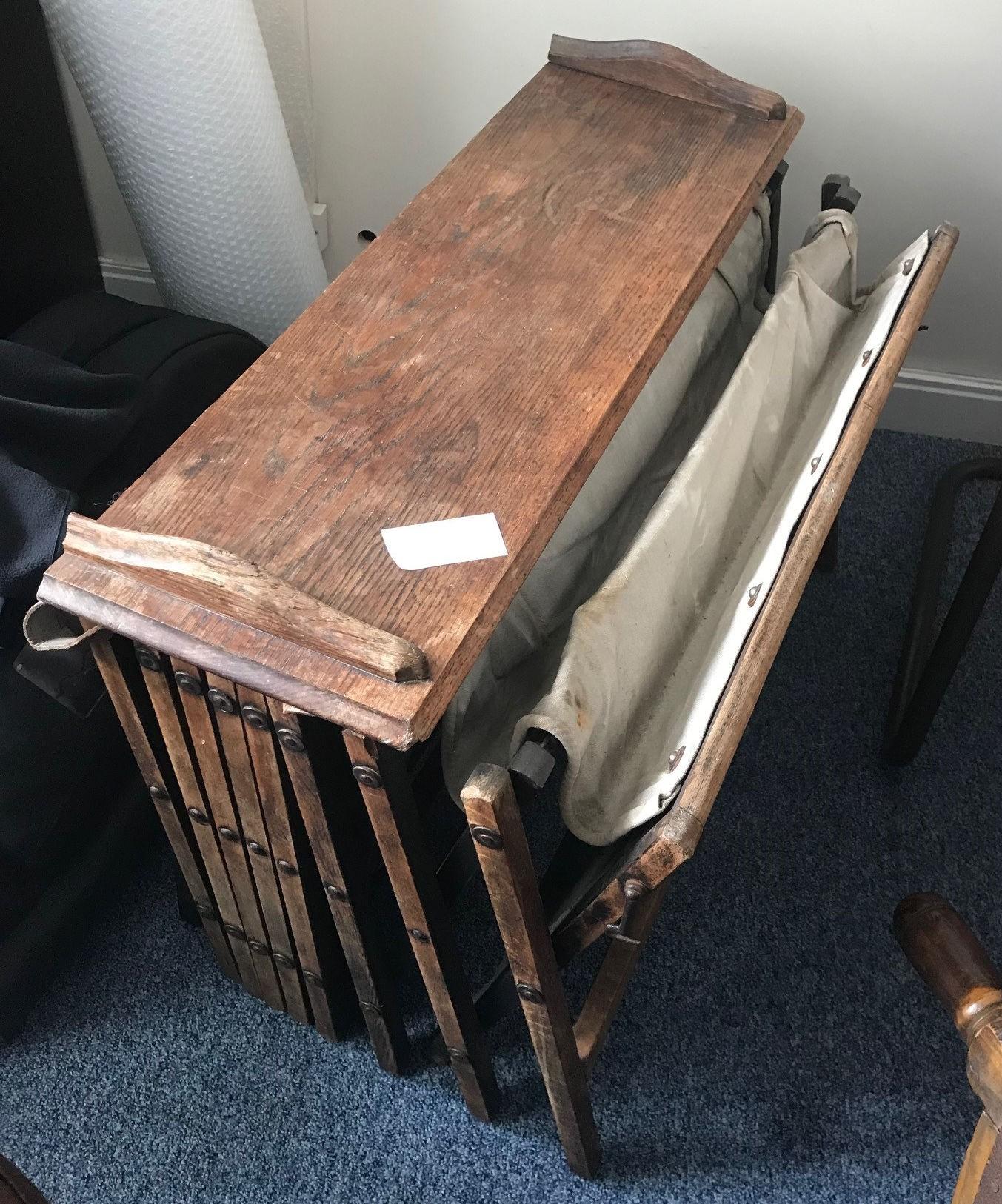 An early 20th century officer's oak and canvas folding concertina campaign bed, 'The Cabinetta' by