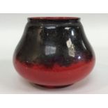 A Bernard Moore Art Pottery shallow vase of tapering ovoid form, decorated with mottled blue and red