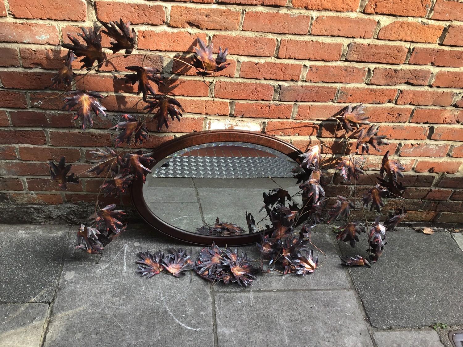 A copper and wire maple leaf wall art / arch hanging, together with an oak oval bevelled mirror (2)