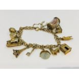 A 9ct gold charm bracelet with twelve 9ct gold charms, including a Hackney cab and an Eiffel Tower