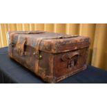 A brown leather suitcase by Finnigans of Manchester, with leather straps, brass lock and with