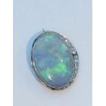 A large green opal and diamond oval brooch, the opal measuring approximately 28x21mm, estimated opal
