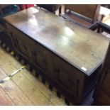 An 18th century oak coffer, the hinged top enclosing storage space, with candle tray, the panelled