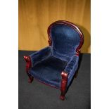 A small stained mahogany doll's armchair, with padded deep blue velvet upholstery, 42cm tall