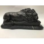 A bronze lion in a recumbent pose, raised on shaped marble plinth base, marked 'Bonheur Paris', 36cm