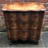 A late 19th century Queen Anne style walnut veneered serpentine chest of three long, graduated