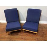 A pair of mid-century teak and beech 'Boomerang' style low easy/lounge chairs, with beech rails to