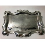 An Edwardian silver dressing table tray with serpentine shaped rim, engraved with foliate swags,