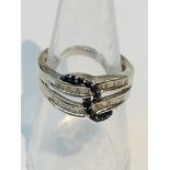 A 9ct white gold dress ring, set with 2 rows of baguette diamonds, entwined with a row of black